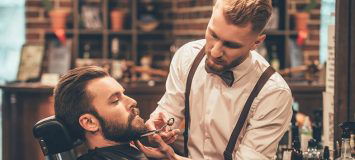 Man receiving beard trim in barber shop