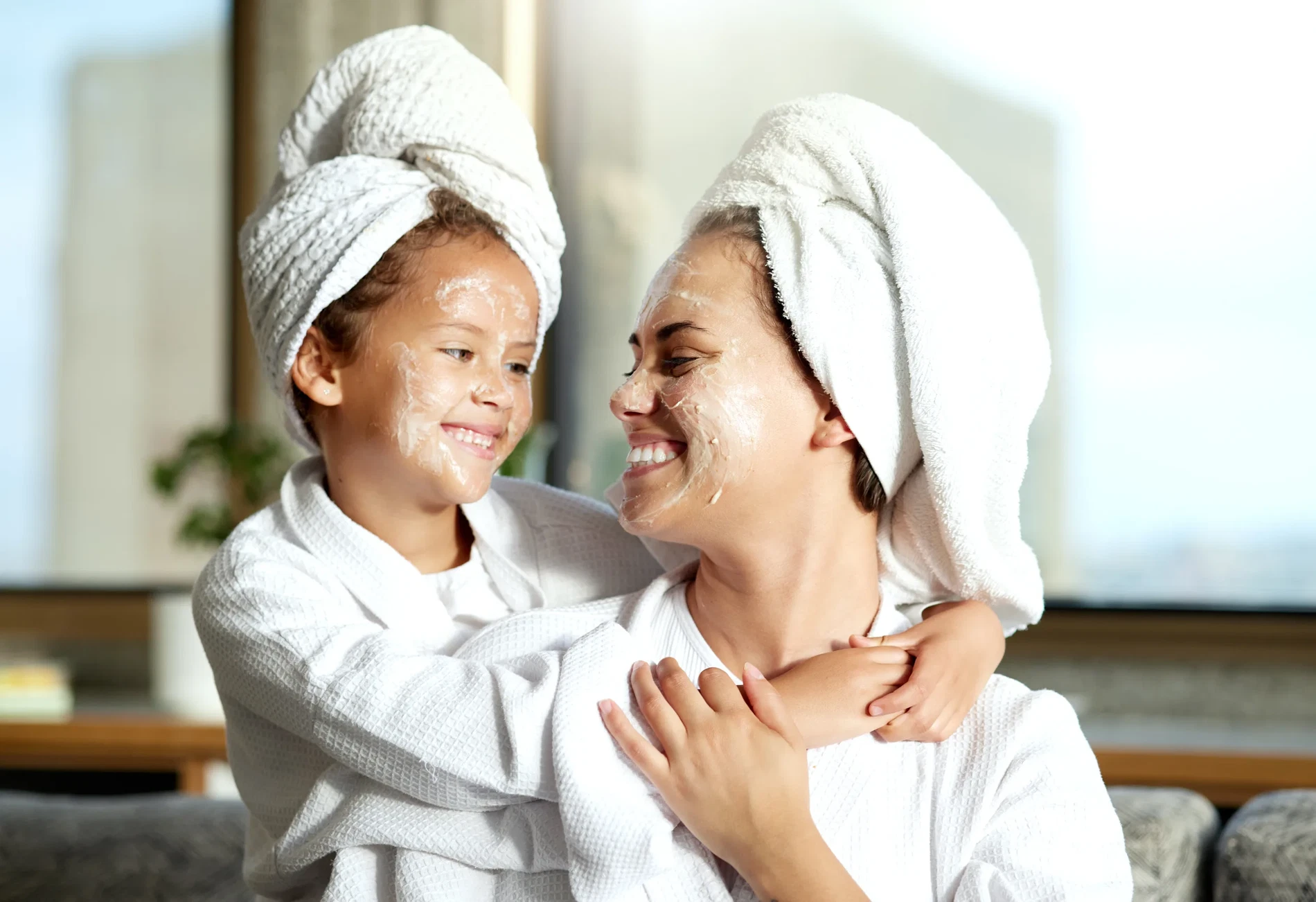 A mother and small daughter in spa bath robes looking at each other in a spa setting